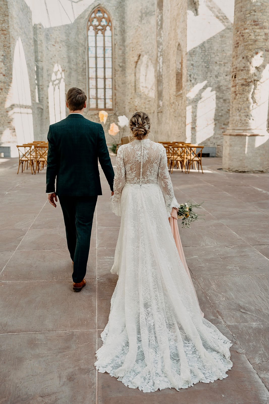 Bruid loopt door kapel, braided updo met bloemen